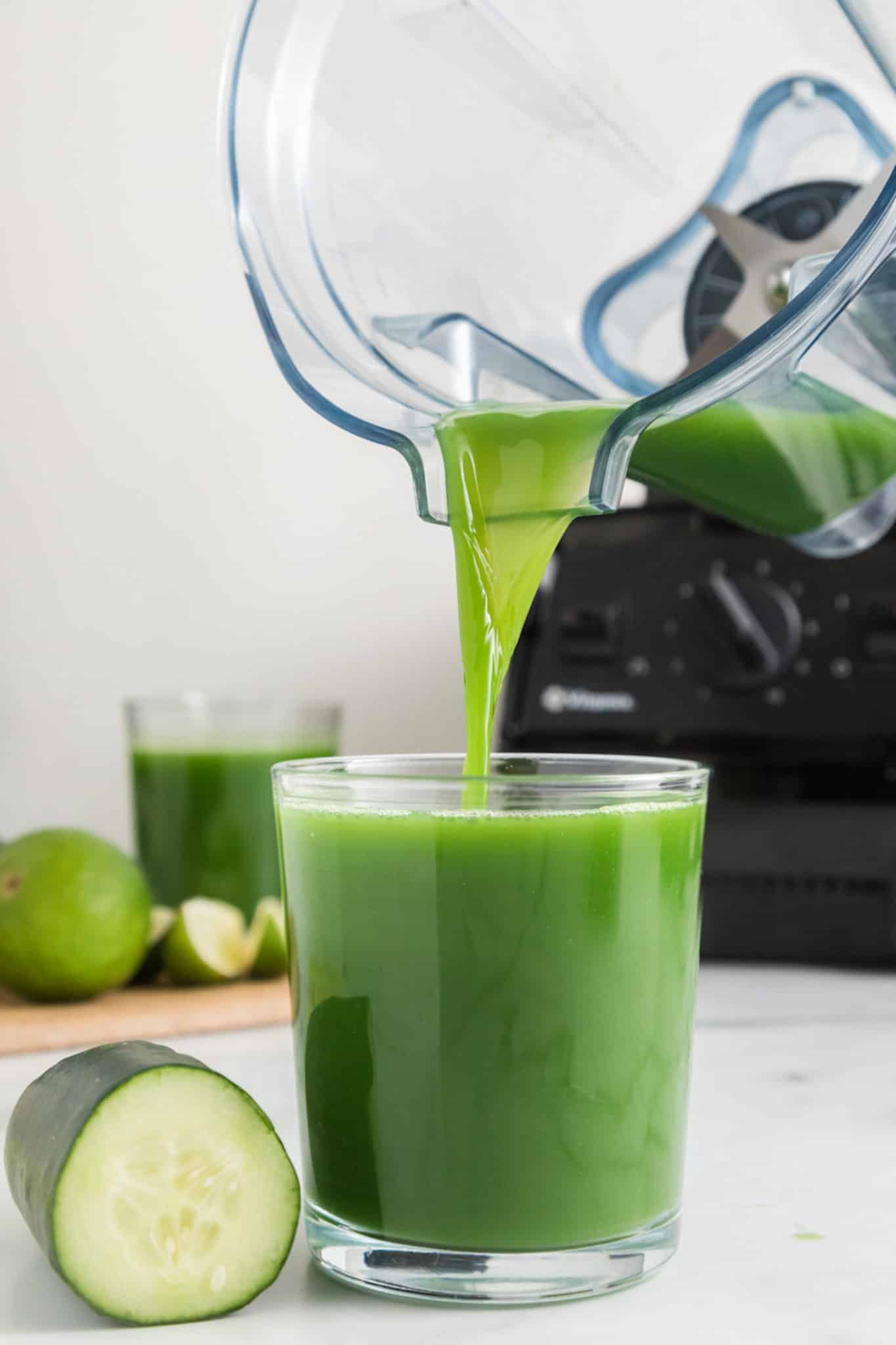 Cucumber juice being poured from a blender to a glass.