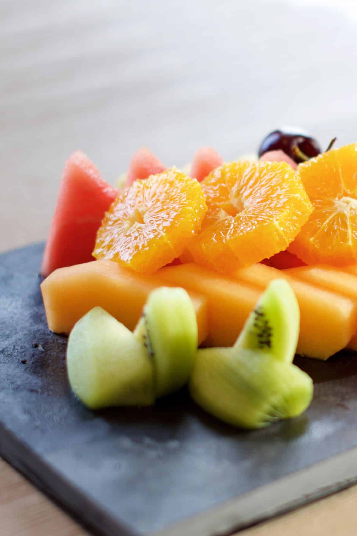 Sliced fruit on a slate platter.