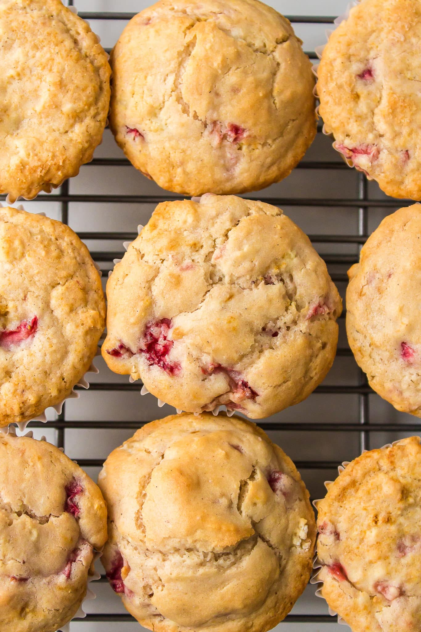 Gluten-free strawberry muffins lined up on a cooling rack.
