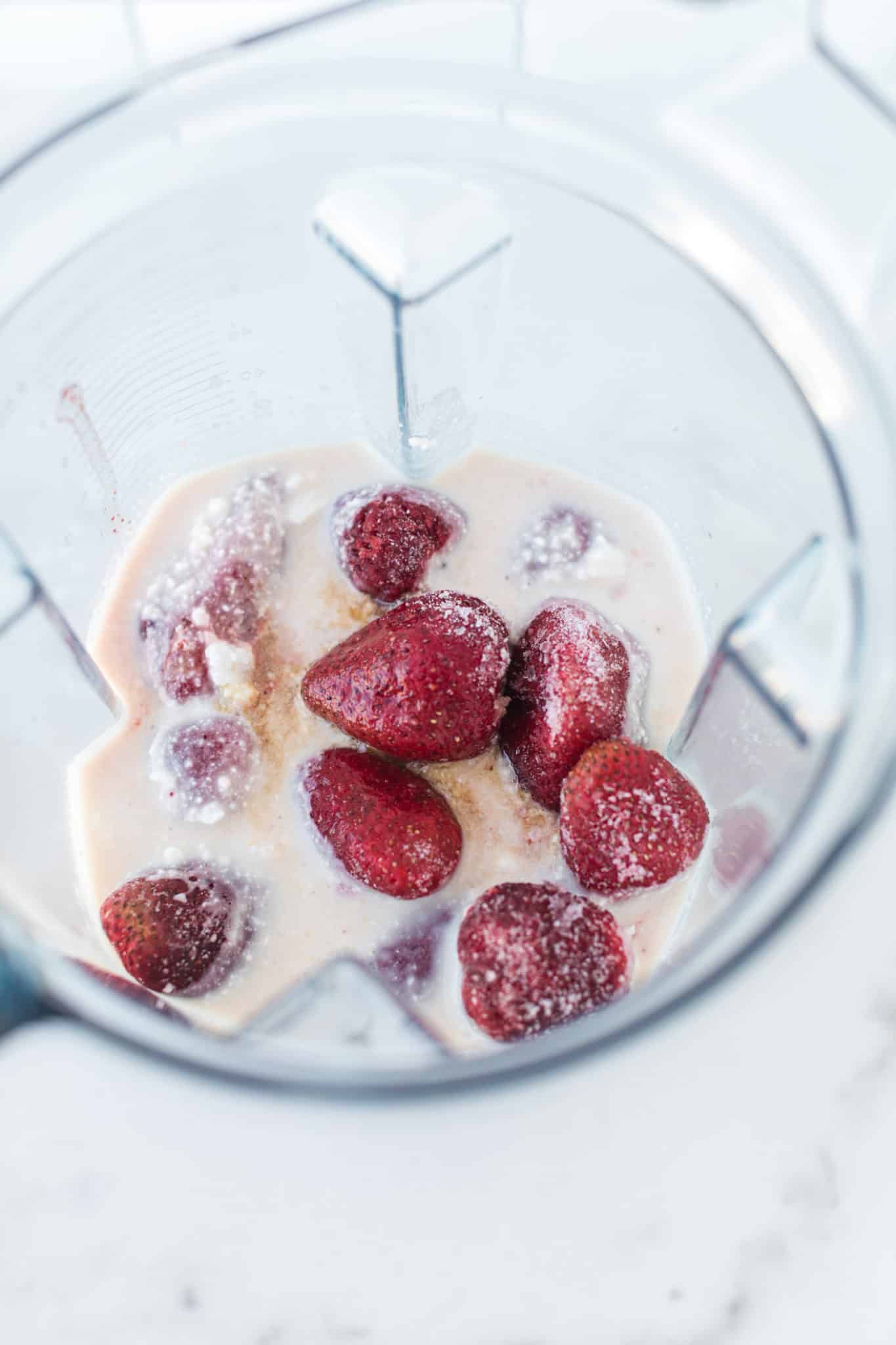 strawberries and coconut milk inside vitamix blender.