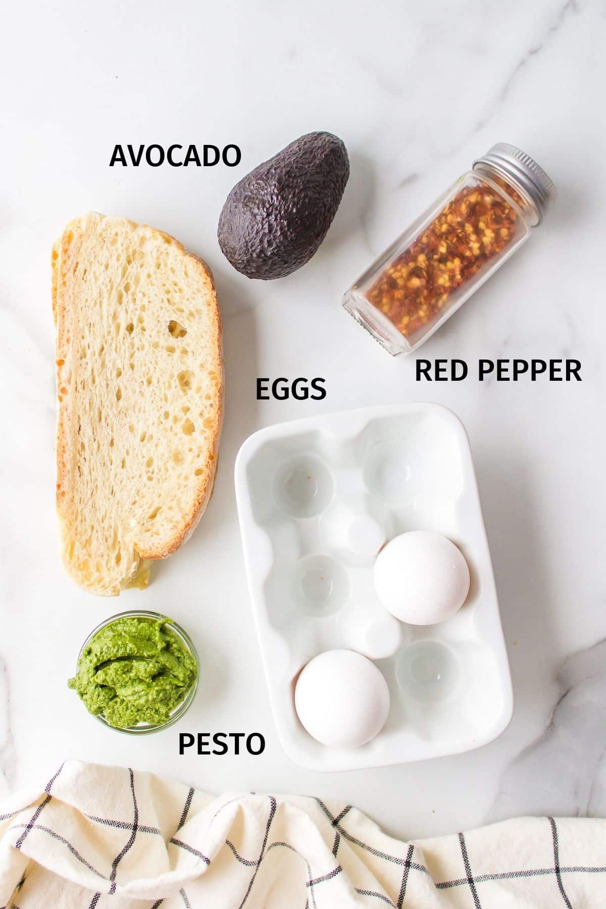 Ingredients for making pesto eggs on avocado toast on a white background.