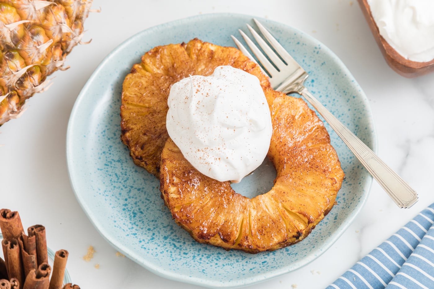 https://www.cleaneatingkitchen.com/wp-content/uploads/2022/06/air-fryer-pineapple-with-coconut-cream-hero.jpg