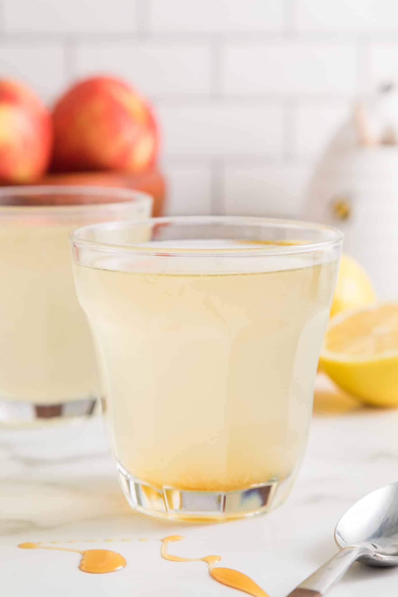 Apple cider vinegar drink in a glass with a floating lemon wheel.