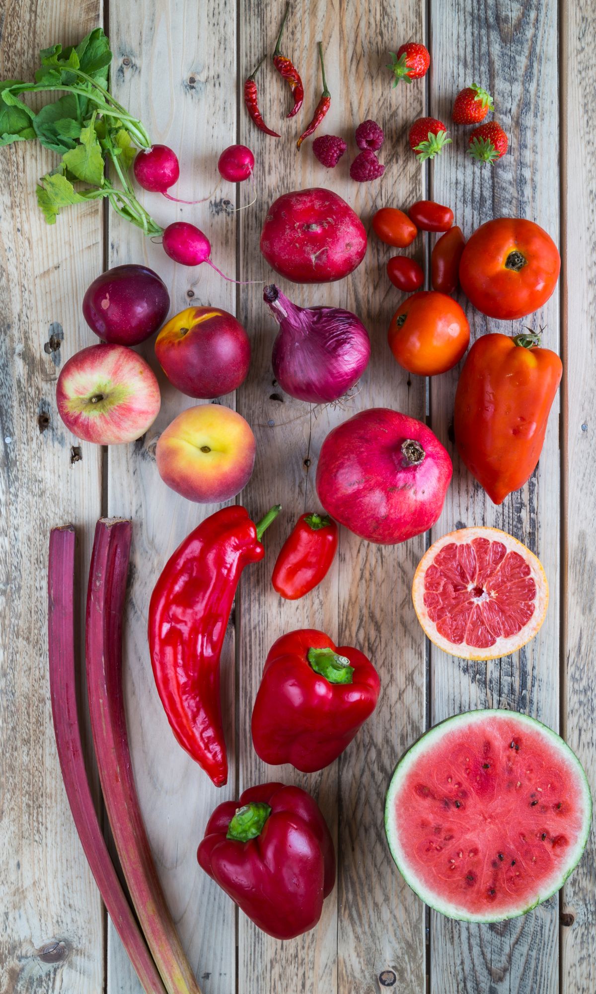 Some of the best red fruits laid out on a wooden table.