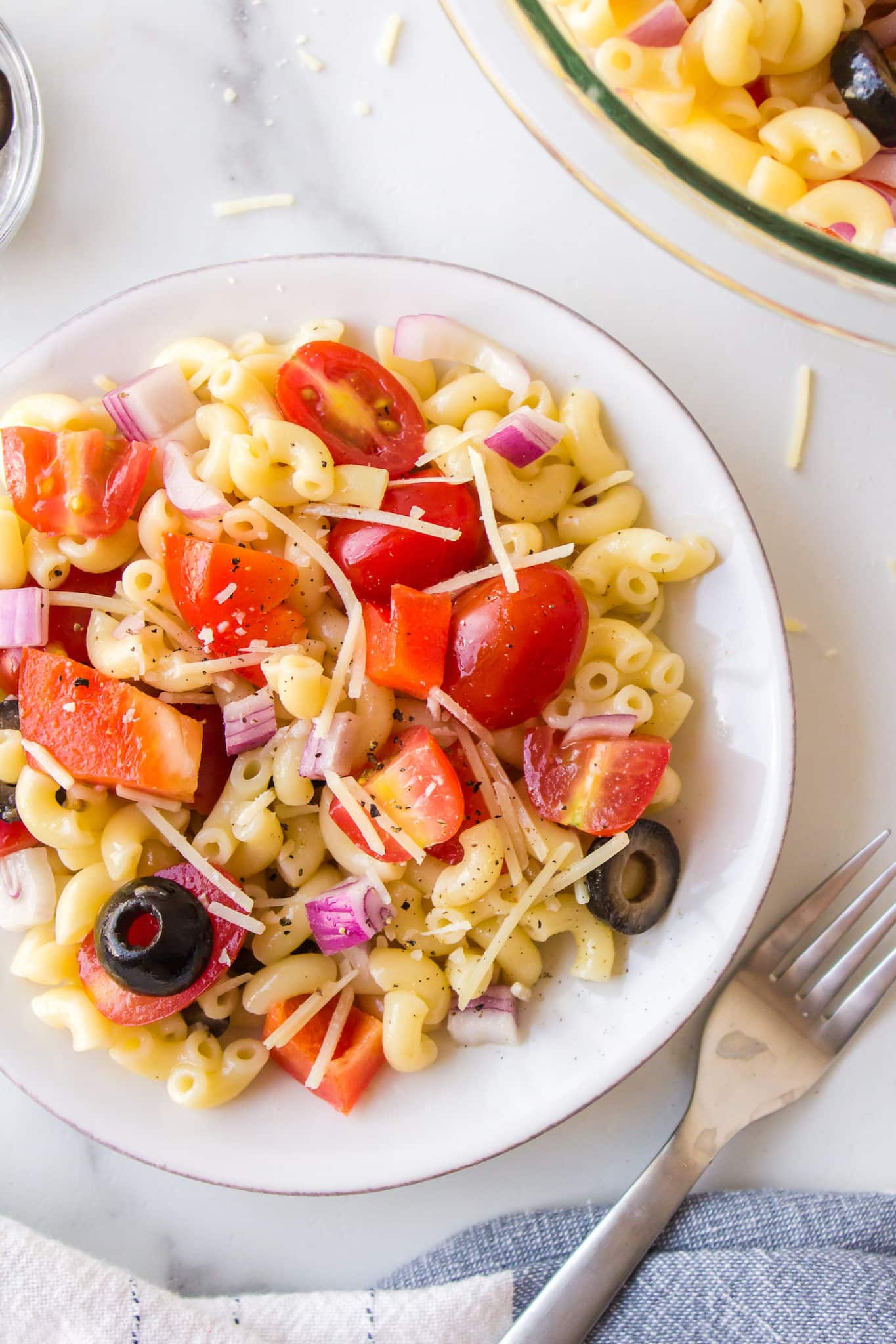 A small serving of veggie pasta salad on a small white plate.