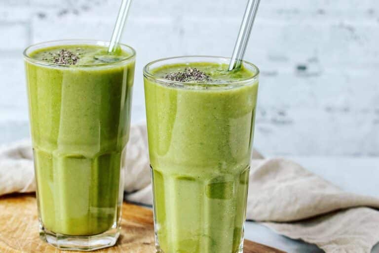 green smoothie on table with chia seeds and glass straw.