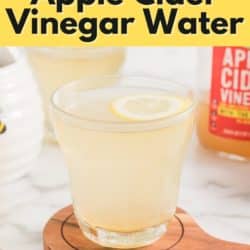 A glass of lemon apple cider vinegar water with a floating lemon wheel.