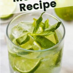 Clear glass filled with mint mojito mocktail with limes and mint.