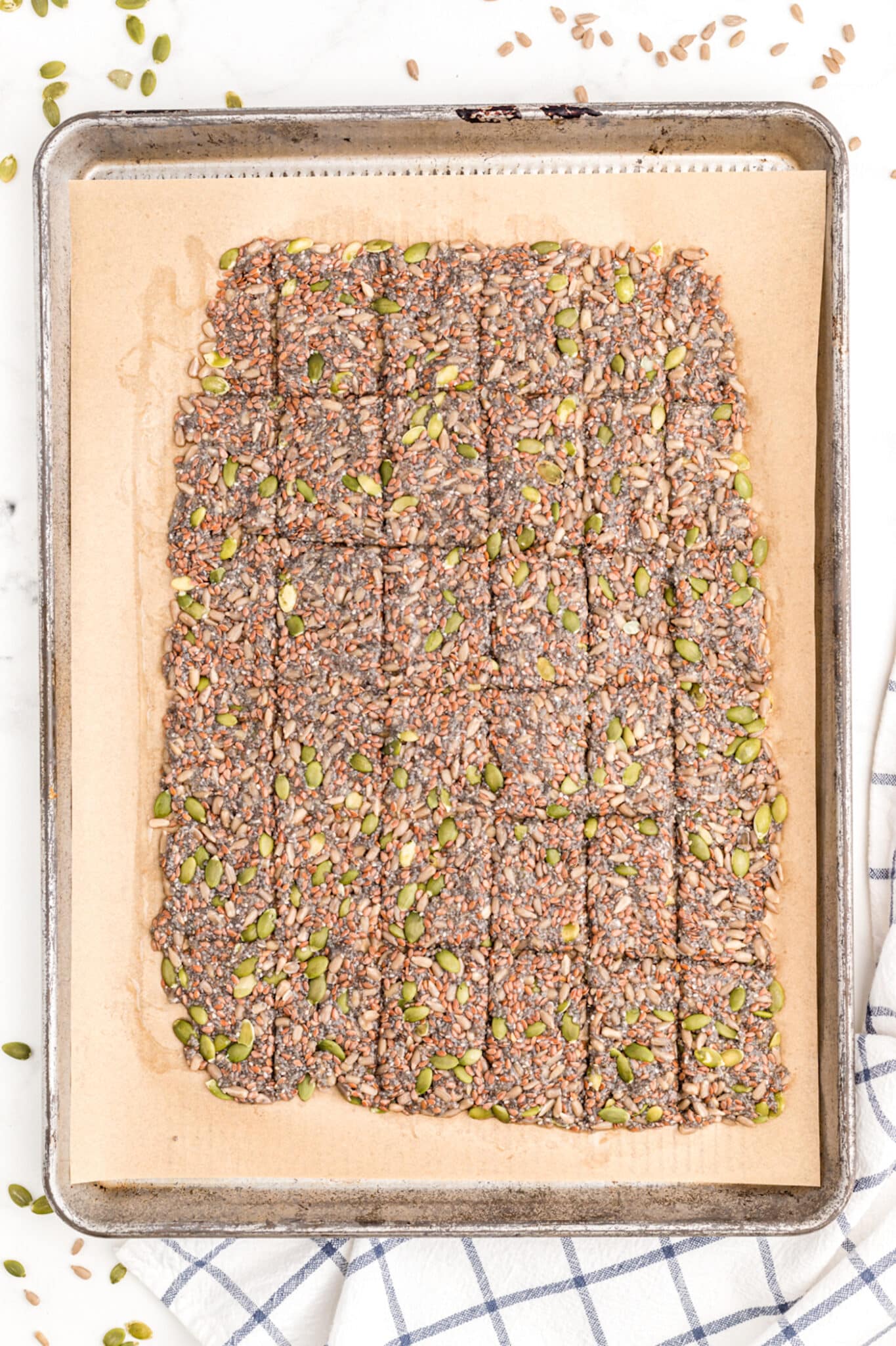 scored seed cracker recipe ready to be baked in oven.