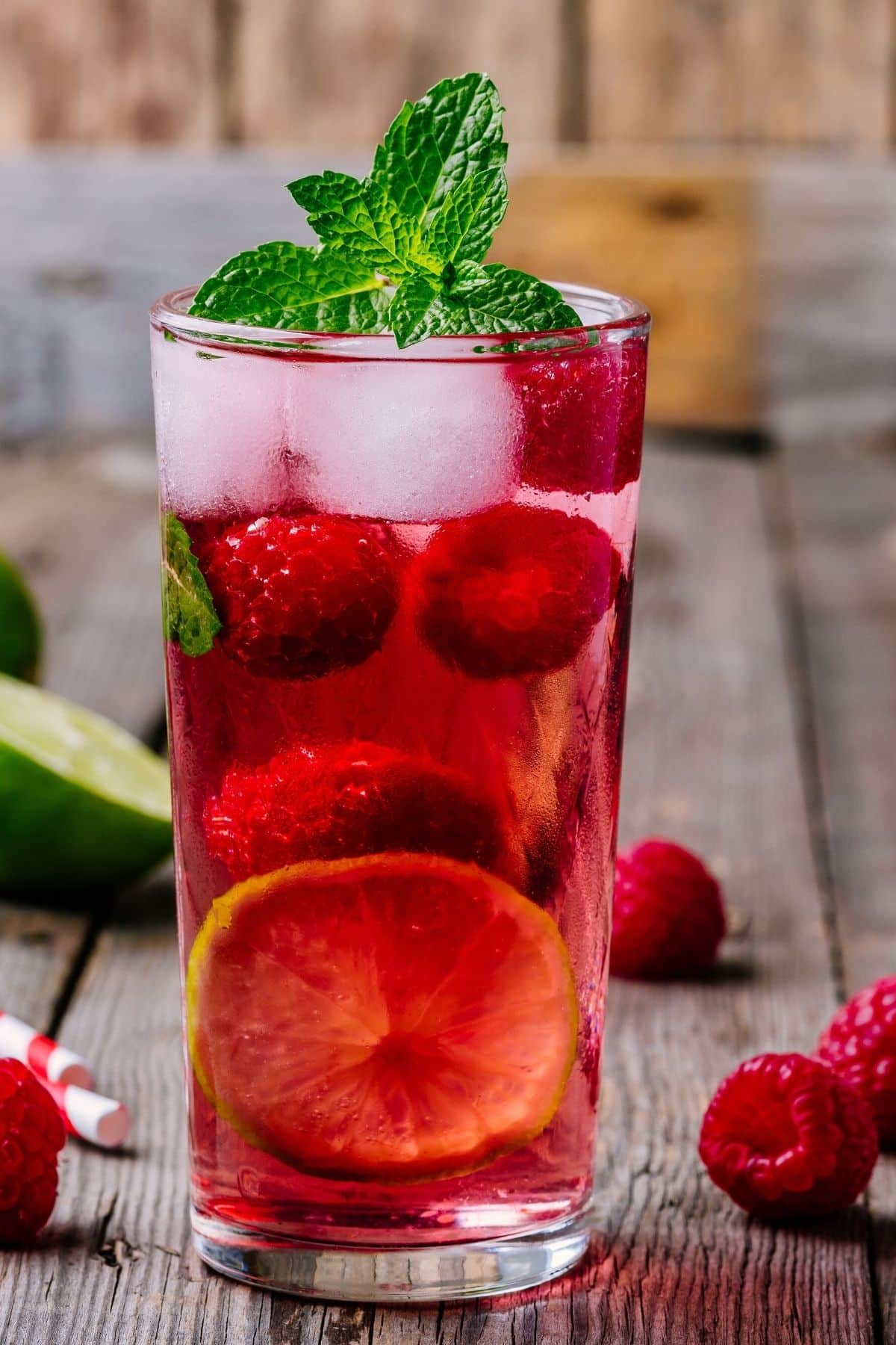 Raspberry mojito in a clear glass with raspberries.