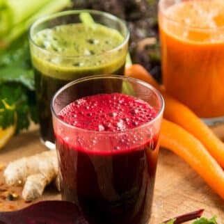 three colorful juice cleanse recipes on table.