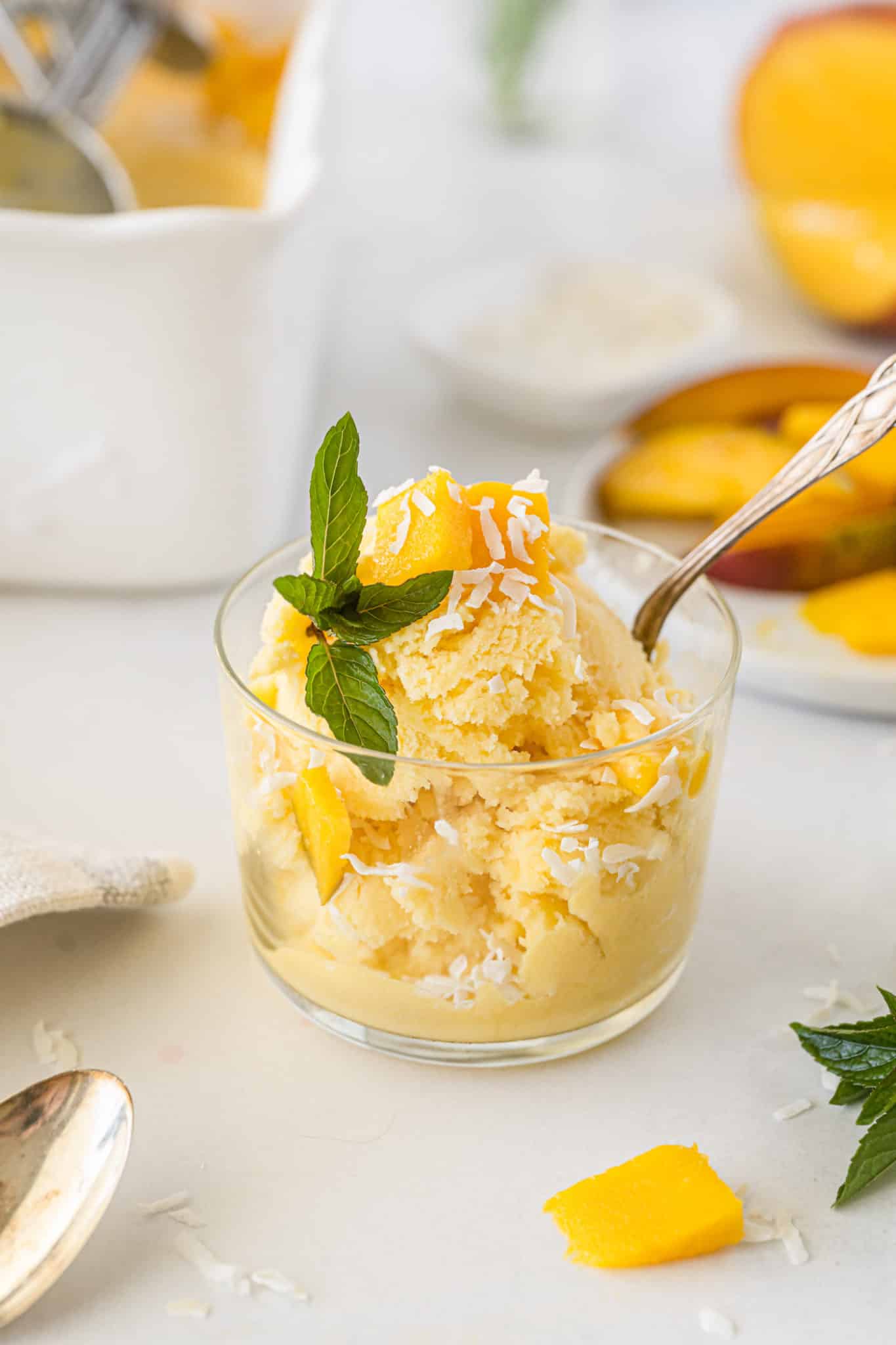 vegan mango ice cream bowl with spoon and fresh mint.
