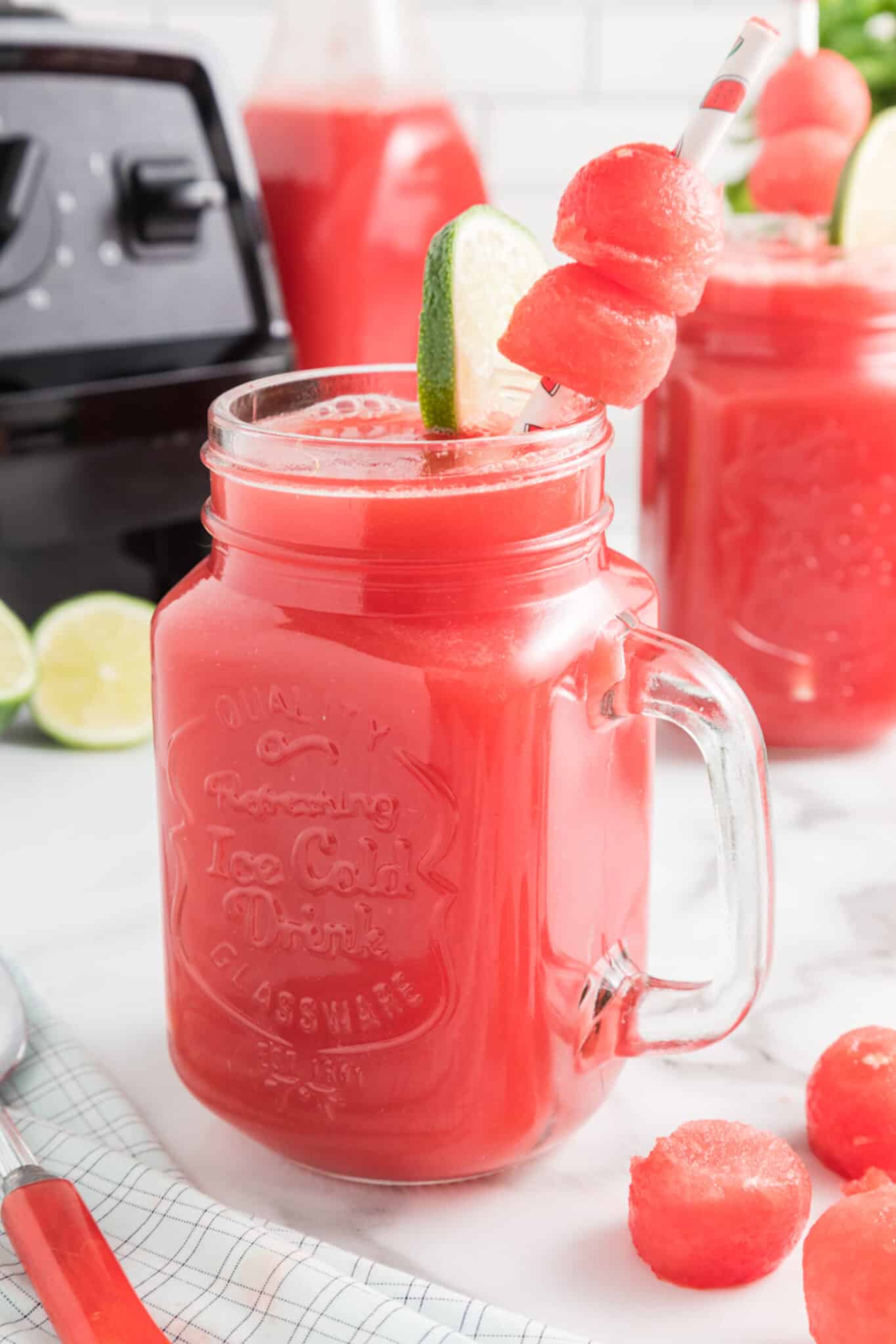 watermelon mint juice in glass with a garnish of lime.