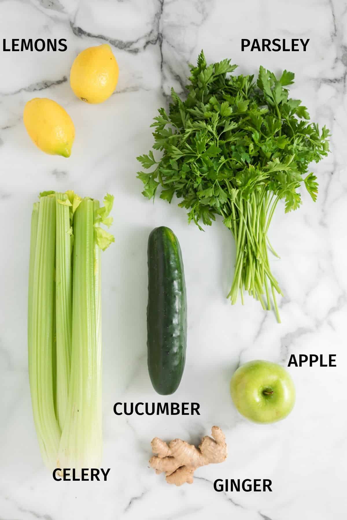 Ingredients for lemon ginger juice on a white marble surface.