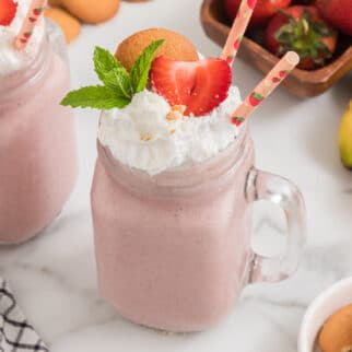 Strawberry Cheesecake Smoothie in a handled mason jar with two straws.
