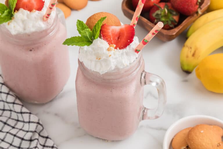 Strawberry Cheesecake Smoothie in a handled mason jar with two straws.