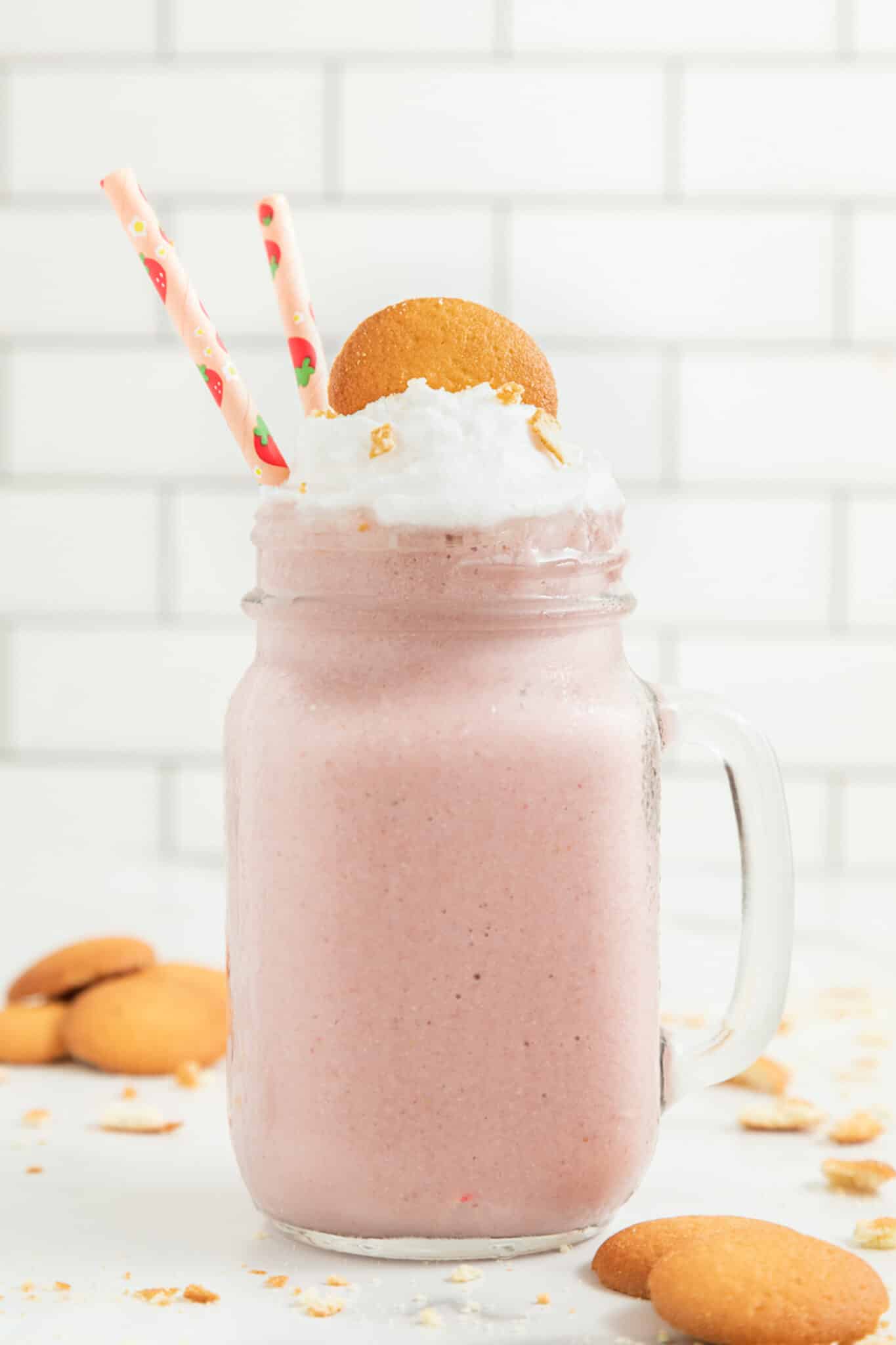 Strawberry Cheesecake Smoothie in a handled mason jar with two straws.