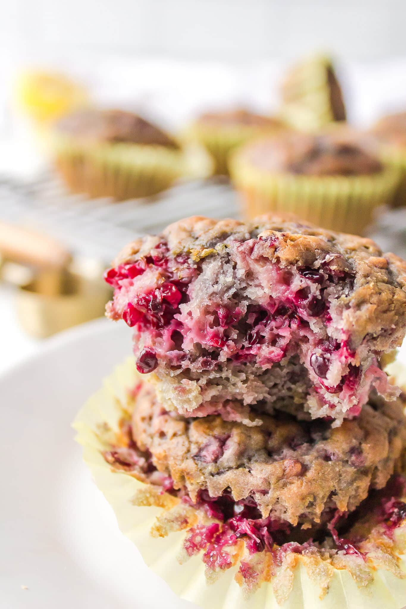 vegan blackberry muffins stacked on each other with a bite taken from one.