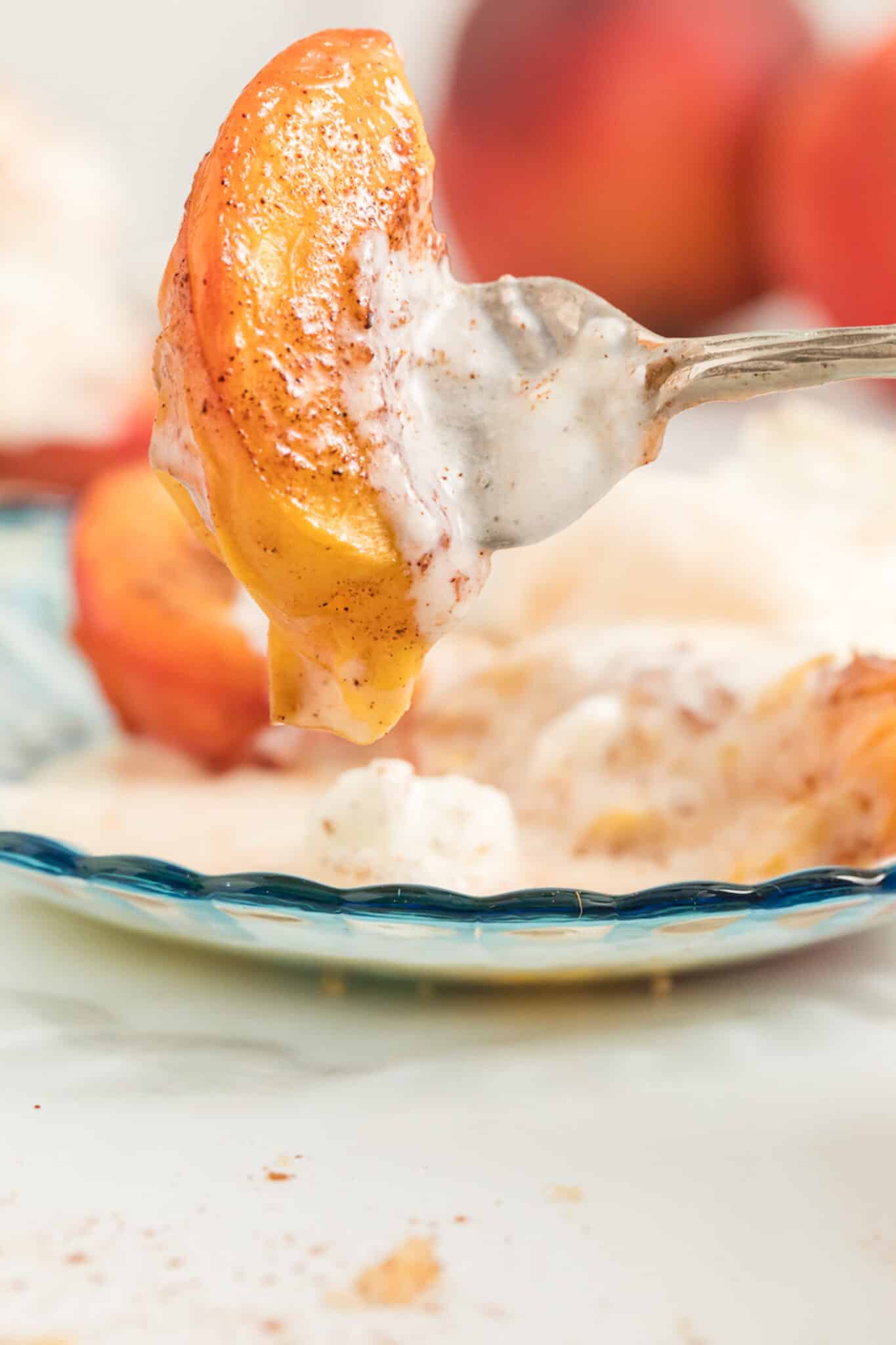 A fork holding a slice of air fried peach with ice cream.