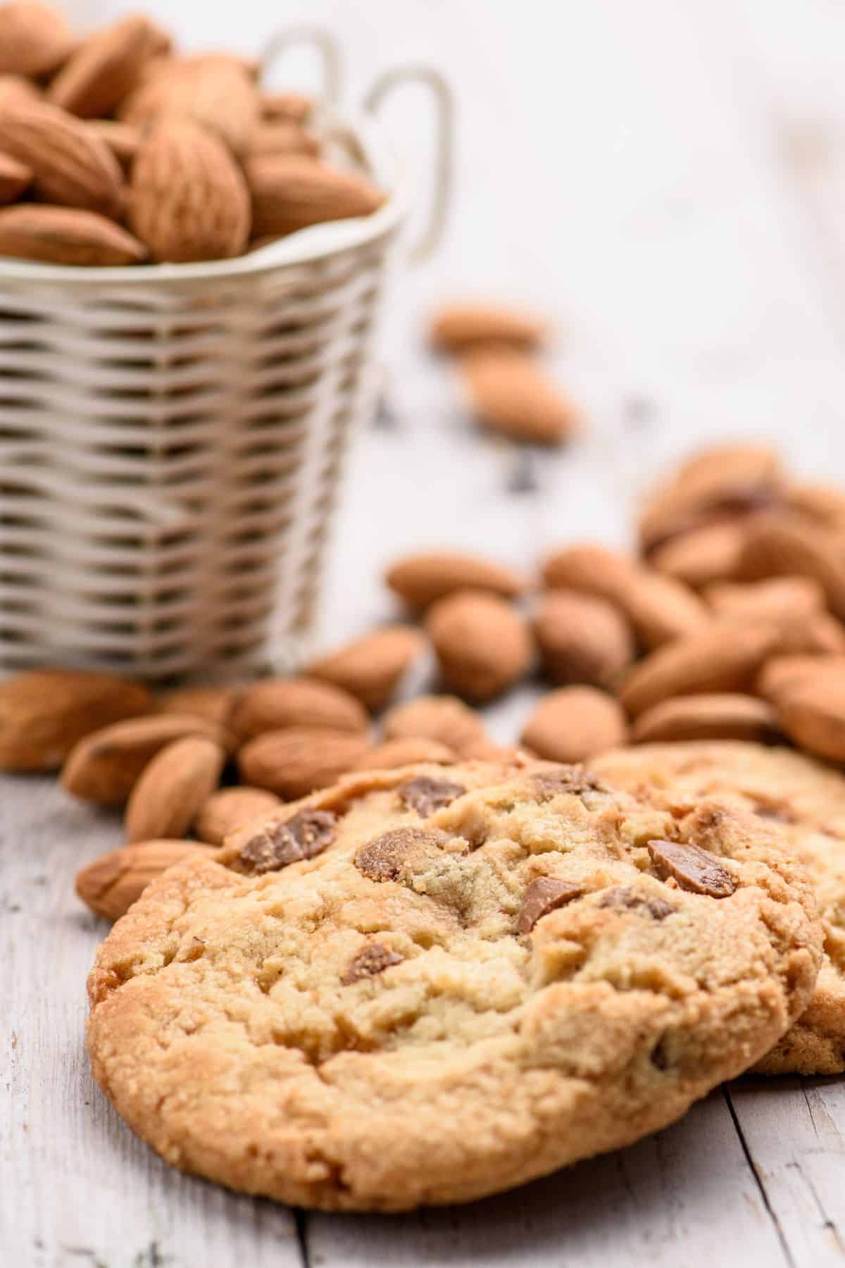Almond flour chocolate chip cookies with almonds in background.