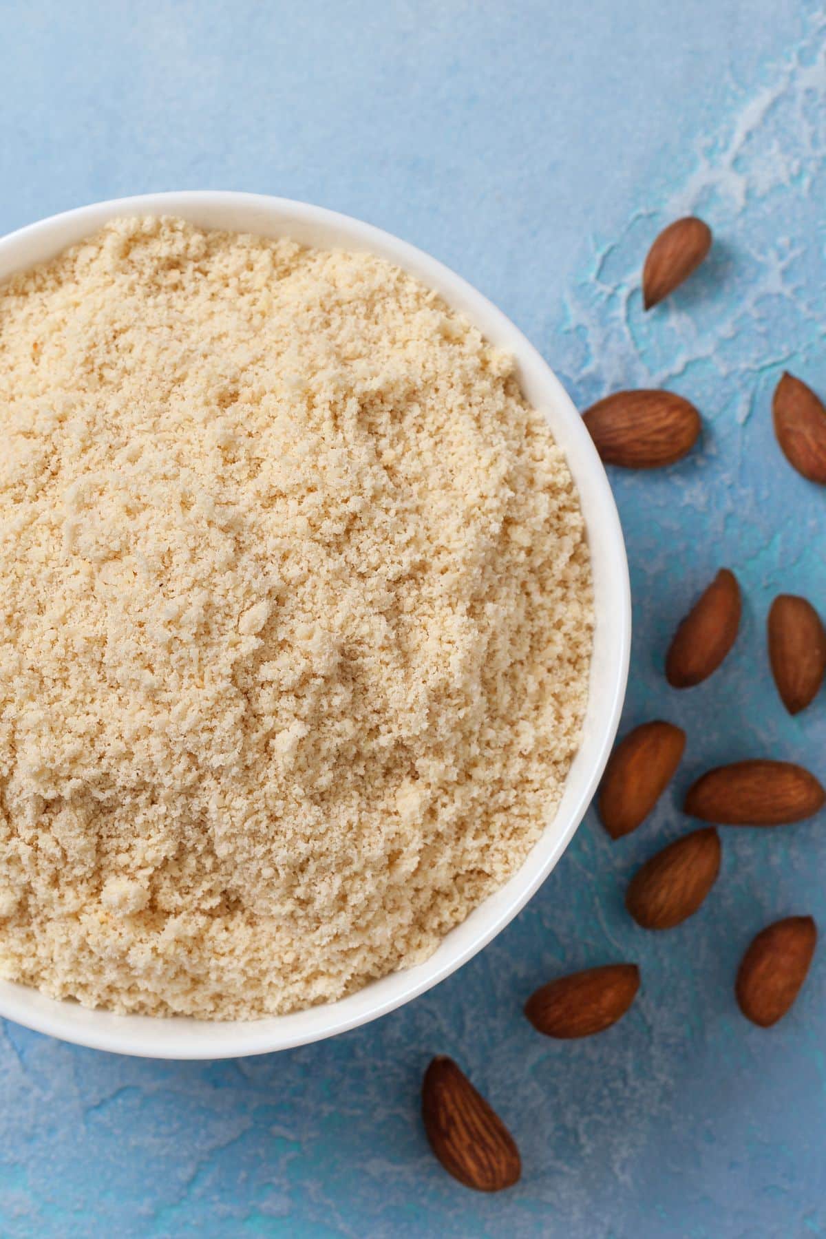 Bowl of almond meal with whole almonds.