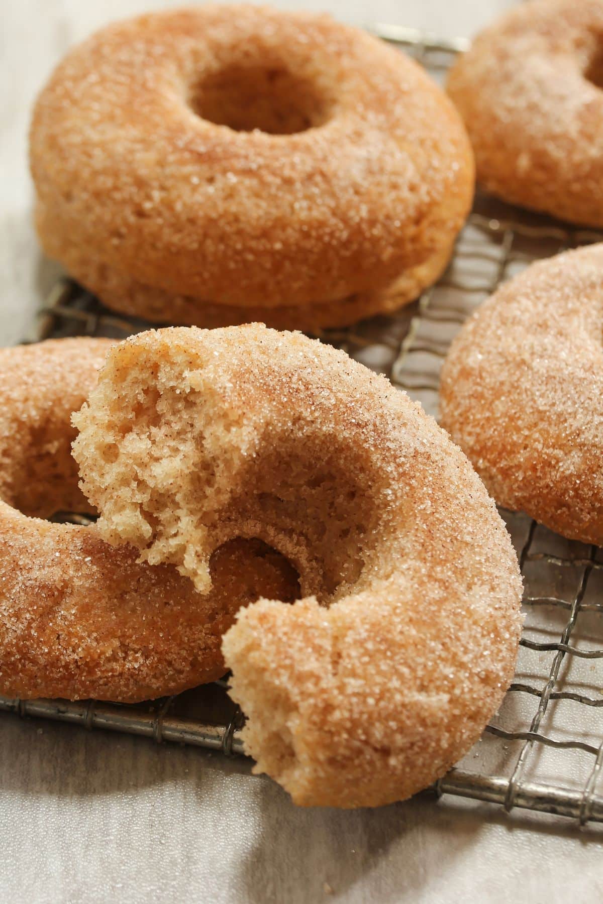 Apple Cider doughnuts with cinnamon sugar on cooling rack.