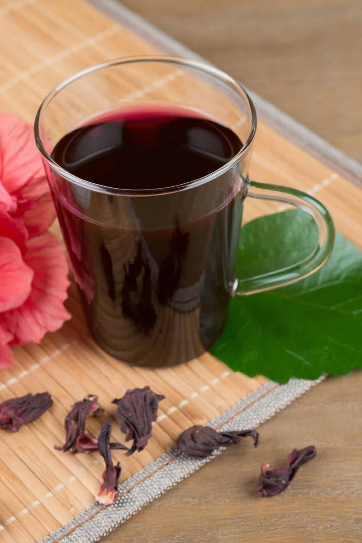 Clear mug filled with deep red hibiscus tea.