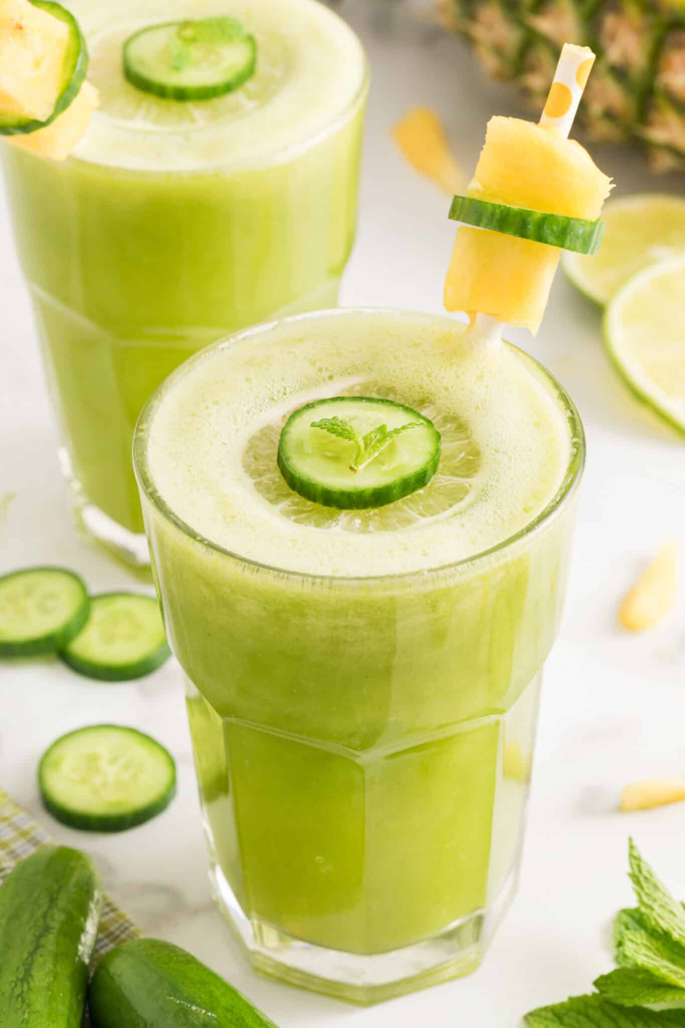 Cucumber pineapple smoothie with a cucumber slice floating on top.