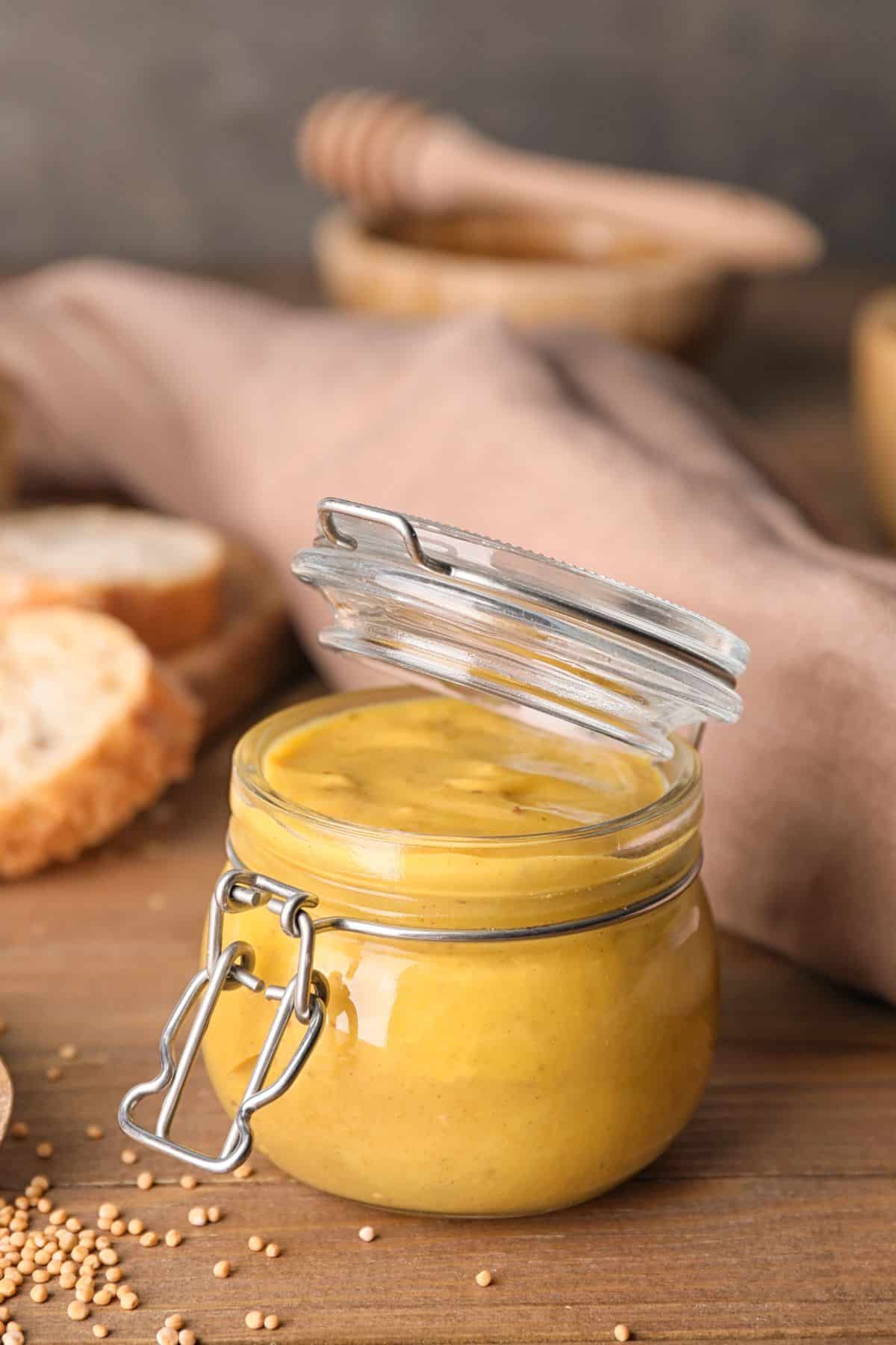 Jar of honey mustard with mustard seeds.