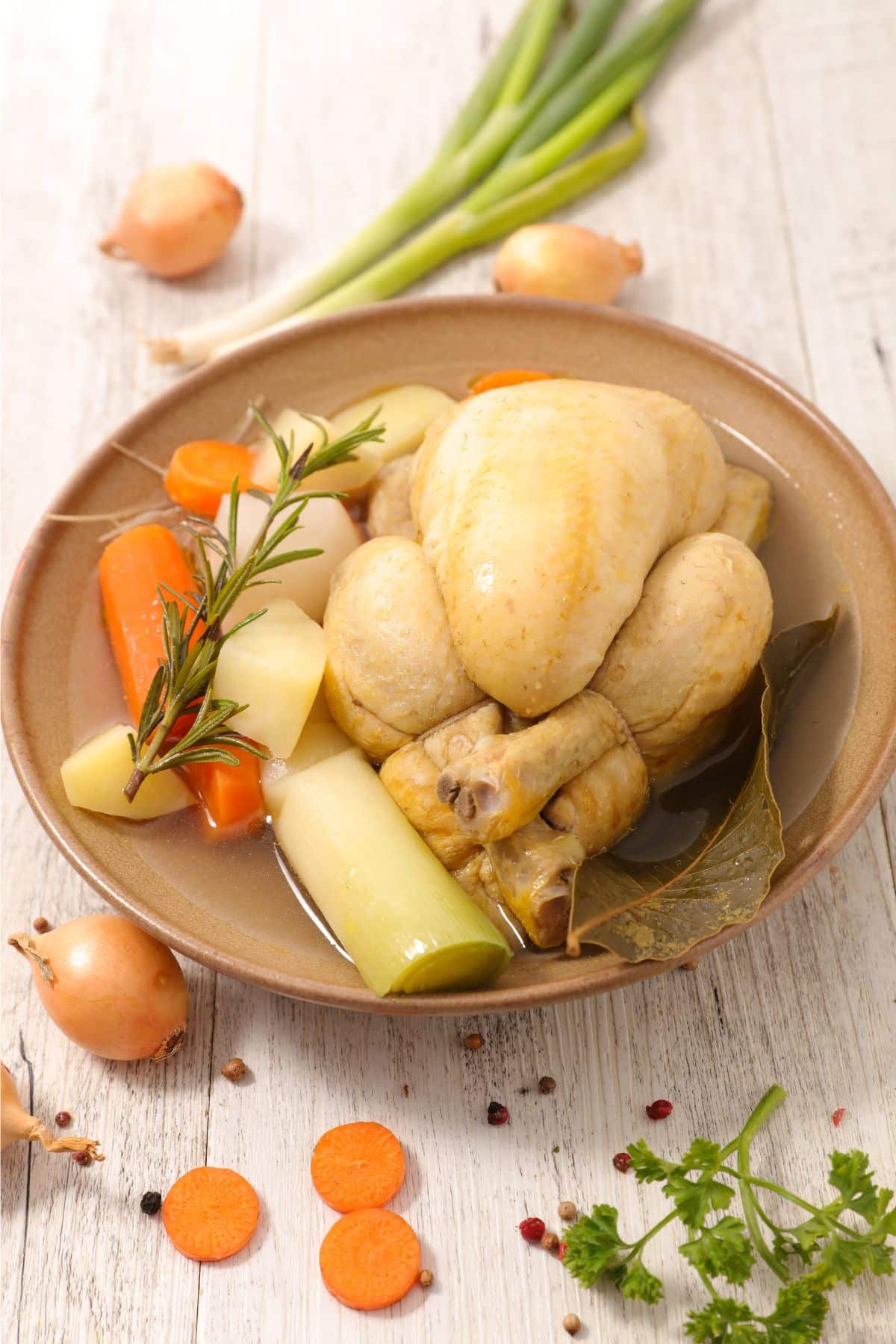 Bowl of cooked vegetables and whole chicken.