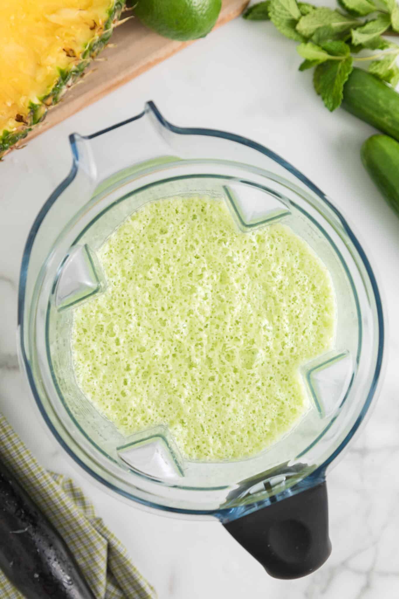 Blender jar filled with ready to drink cucumber pineapple smoothie.