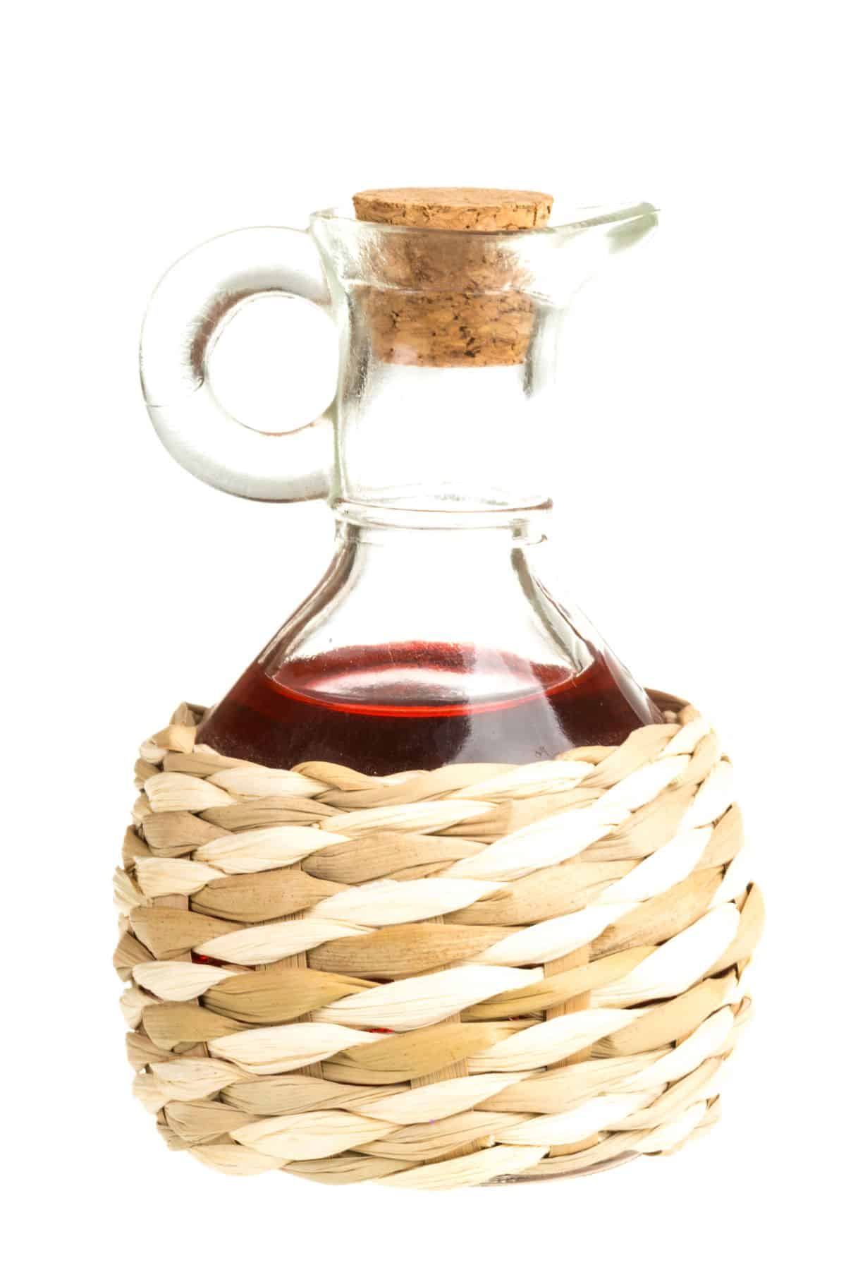 Bottle of red wine vinegar in woven case.