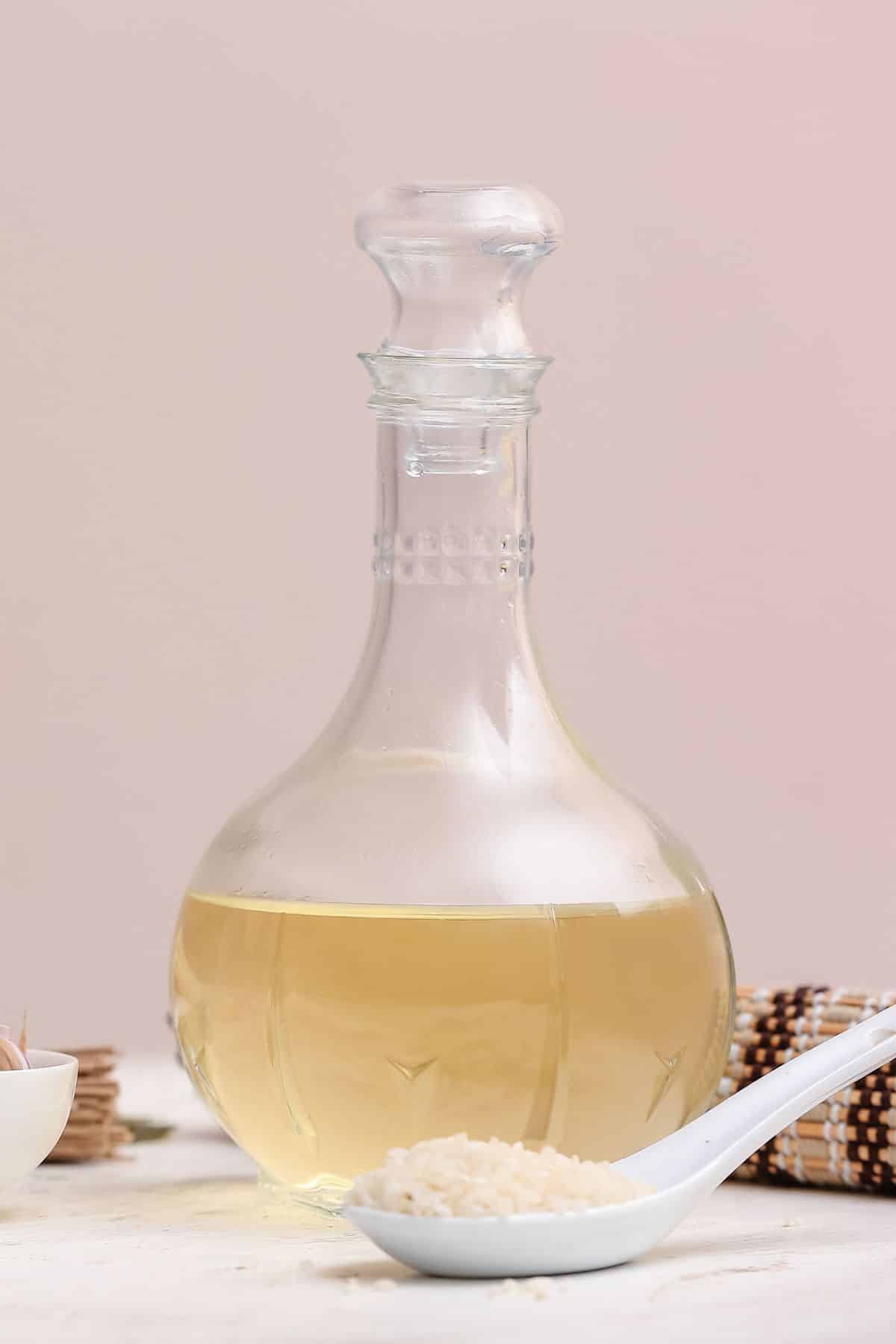 Bottle of rice wine vinegar with scoop of rice.