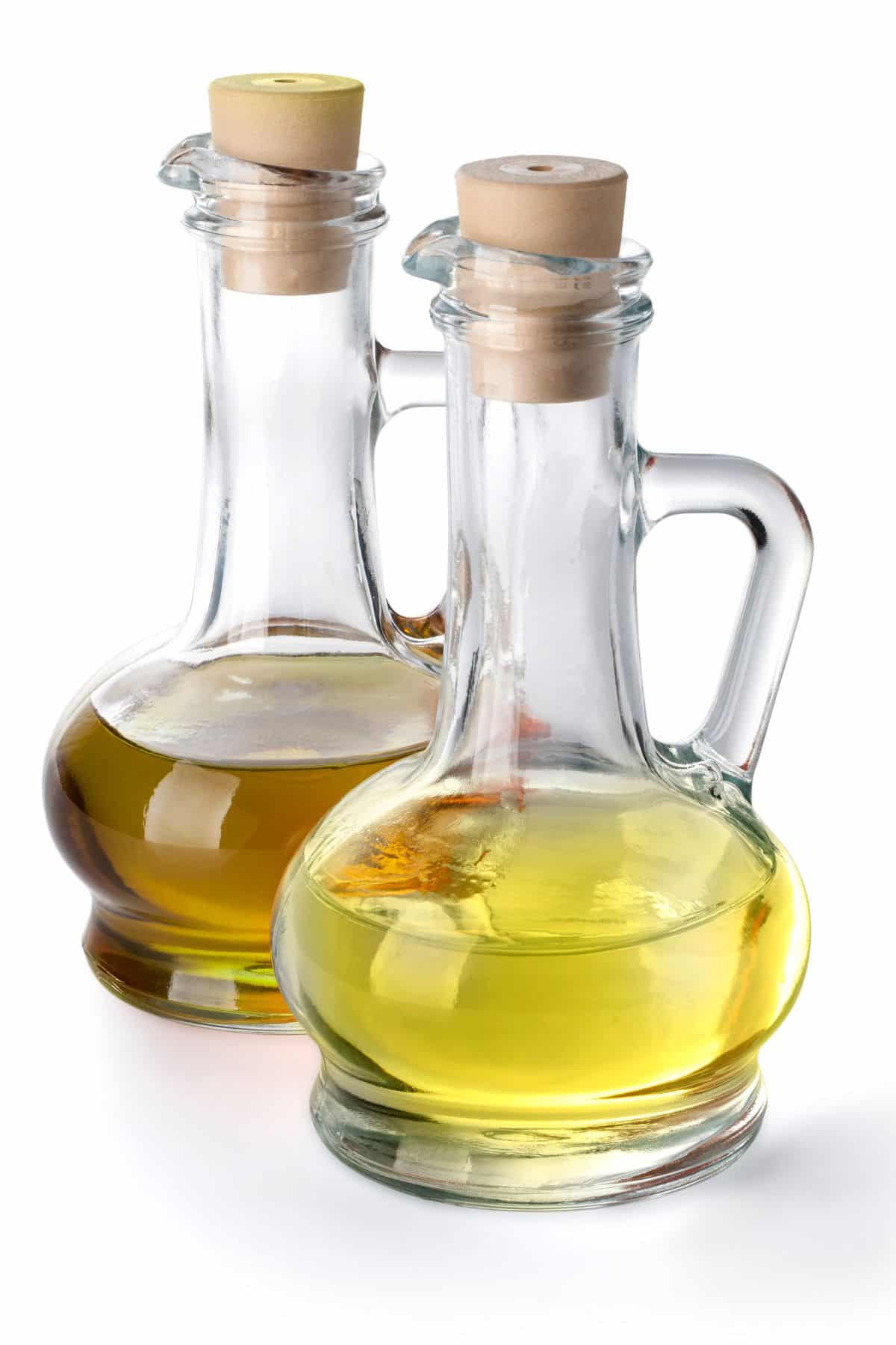 Bottle of olive oil next to bottle of vegetable oil.