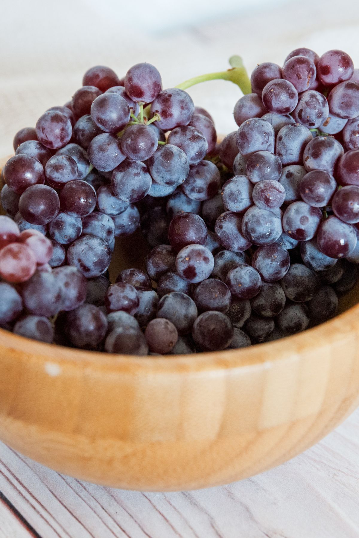 A bamboo bowl filled with zante currants on the vine.