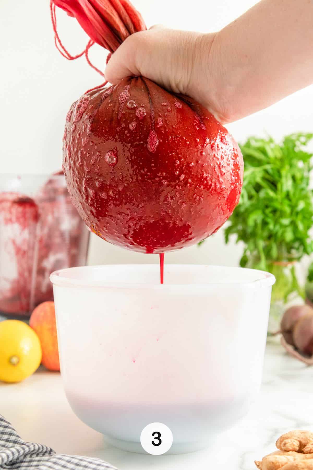 straining beet juice through nut milk bag.