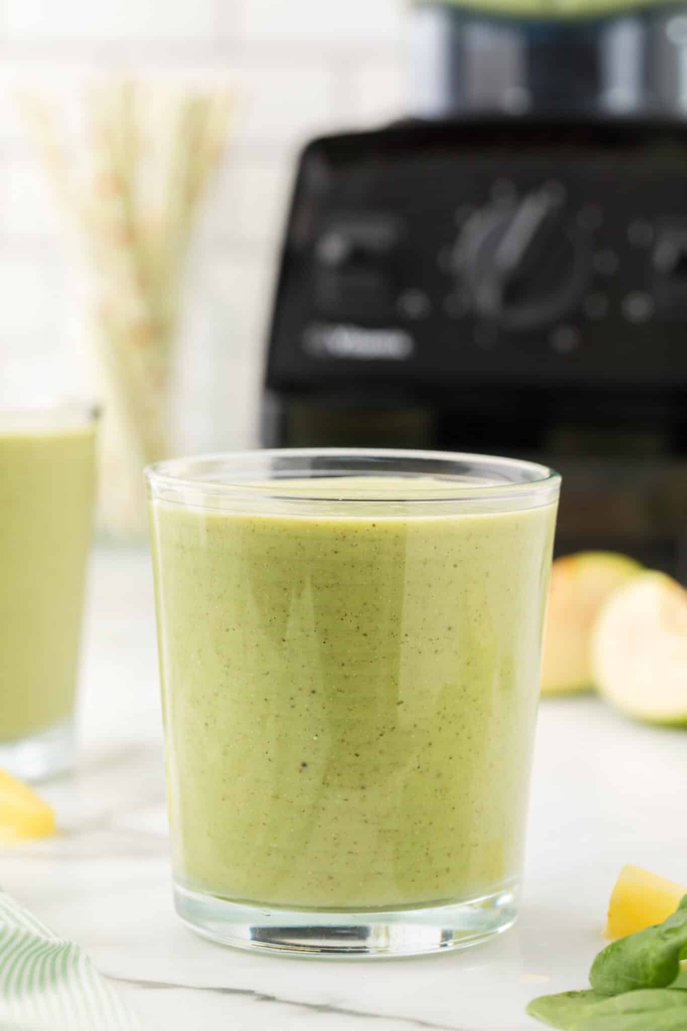 A short glass filled with banana spinach smoothie.