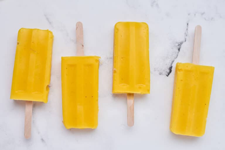 frozen mango popsicles on a table.