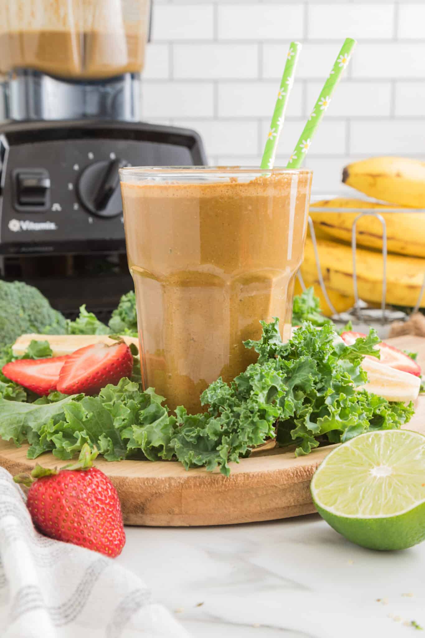 Cancer-fighting cocoa green smoothie in a glass with two green straws.