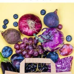 Many blue and purple fruits and veggies spilling out of a paper bag with text.