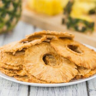 A pile of dehydrated pineapple slices on a white plate.