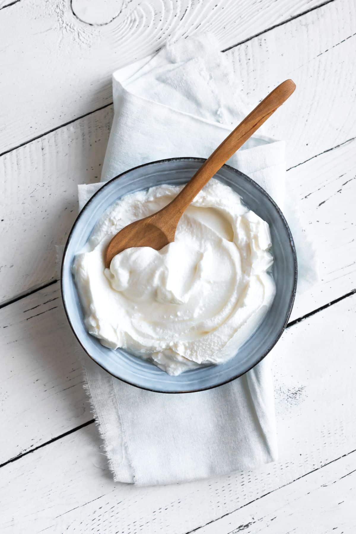 Bowl of Greek yogurt on white towel.