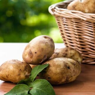 Potatoes in basket and on tabletop.