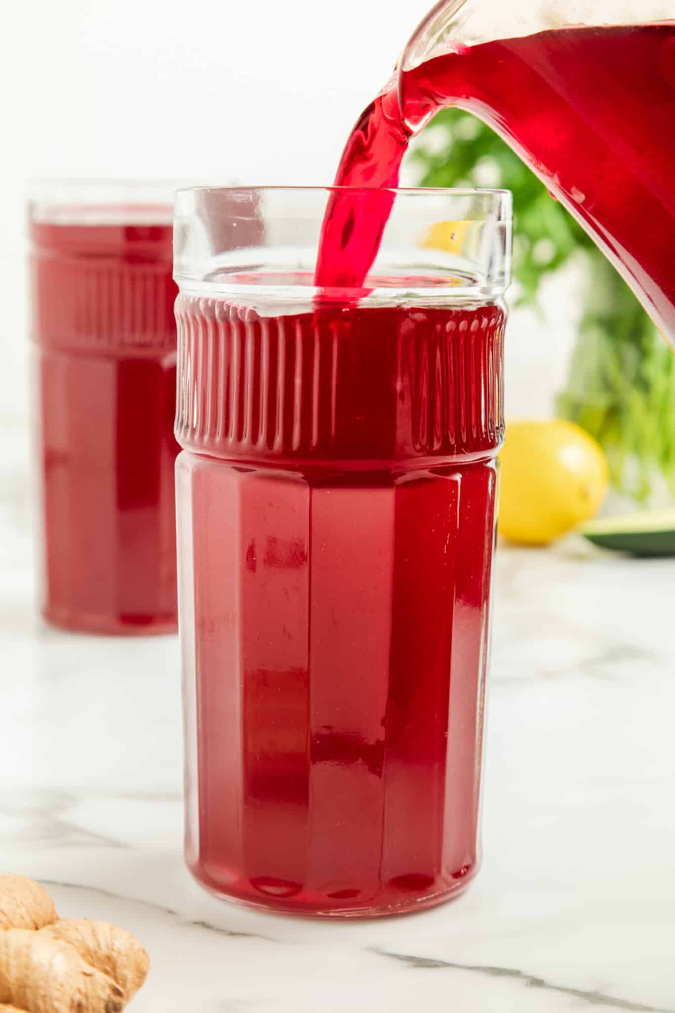 pouring homemade beet juice into a glass.