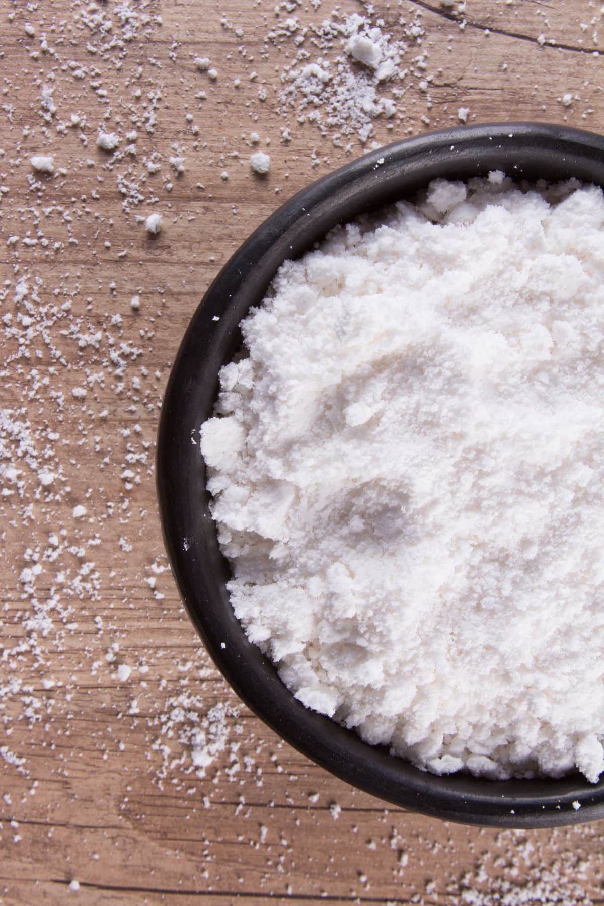 Bowl of tapioca flour on wooden surface.