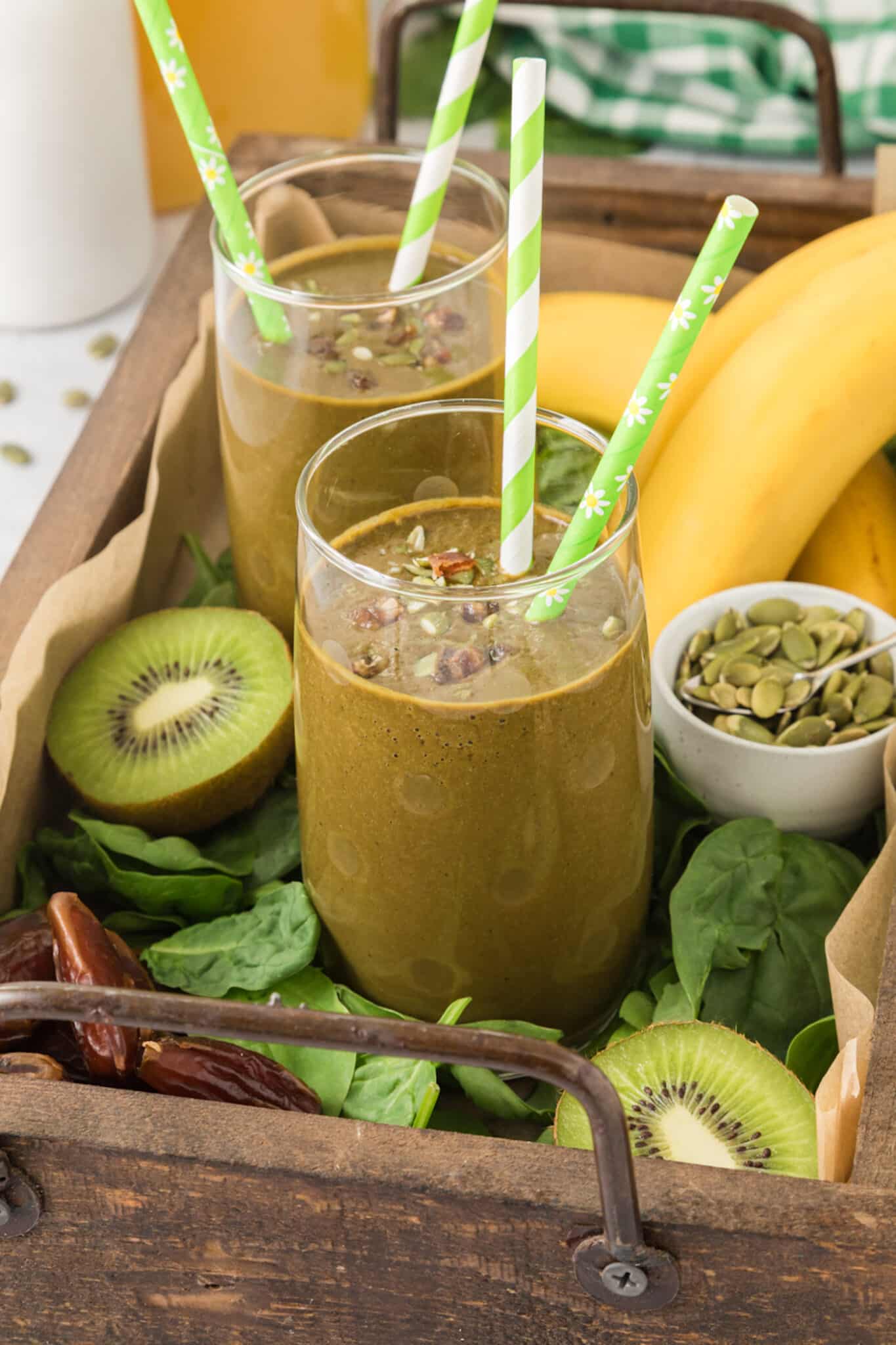 Two glass of iron rich smoothie each with two green straws.