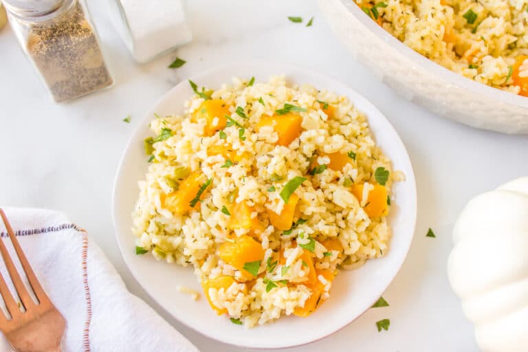 A small white plate filled with a serving of pumpkin rice.