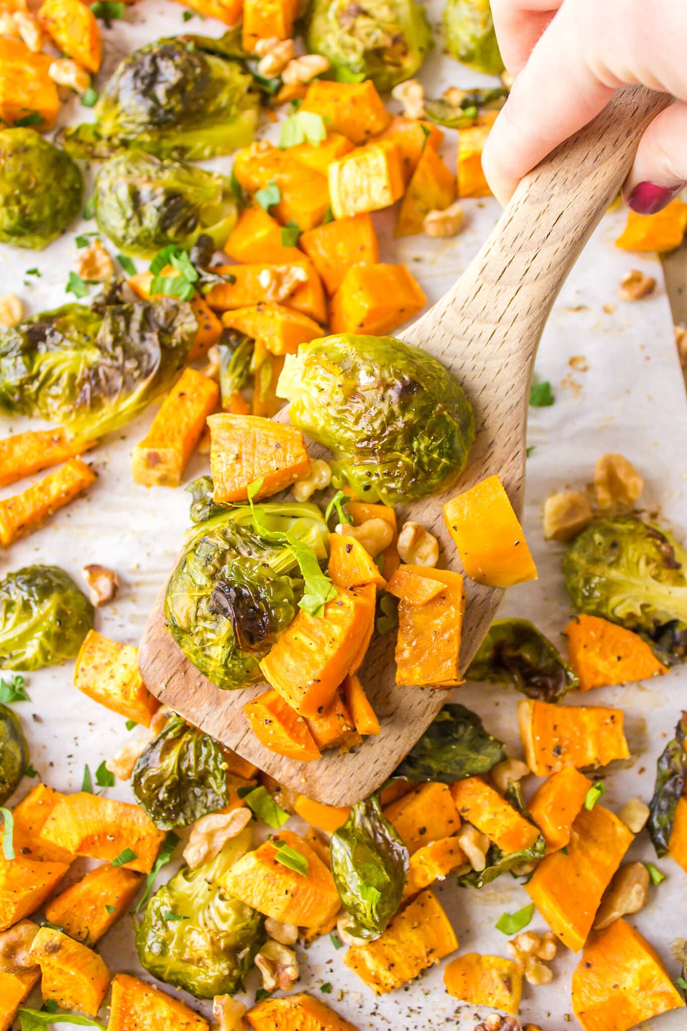 Roasted brussels sprouts and sweet potatoes on a baking sheet.