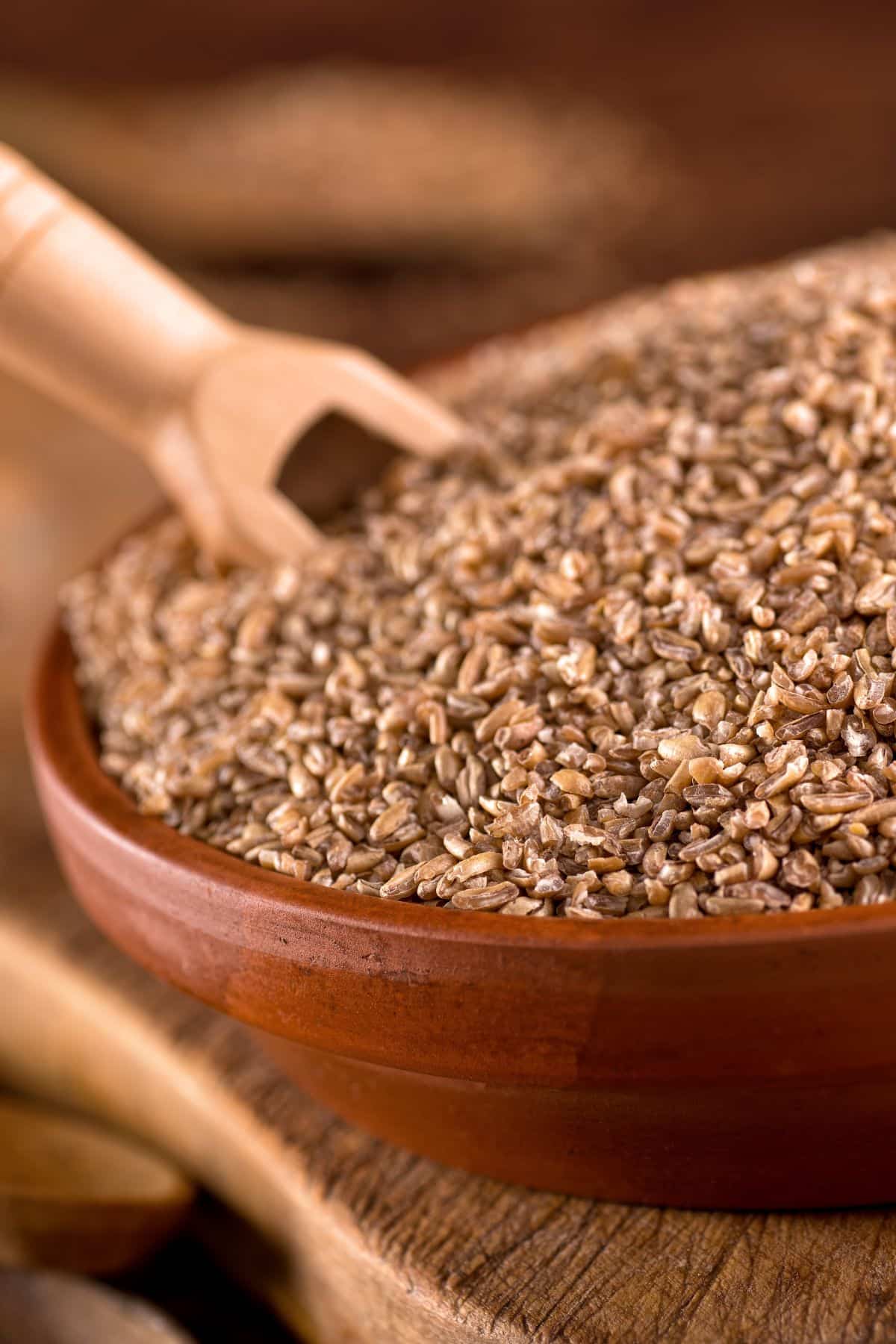 Bowl of bulgur wheat on wooden surface.