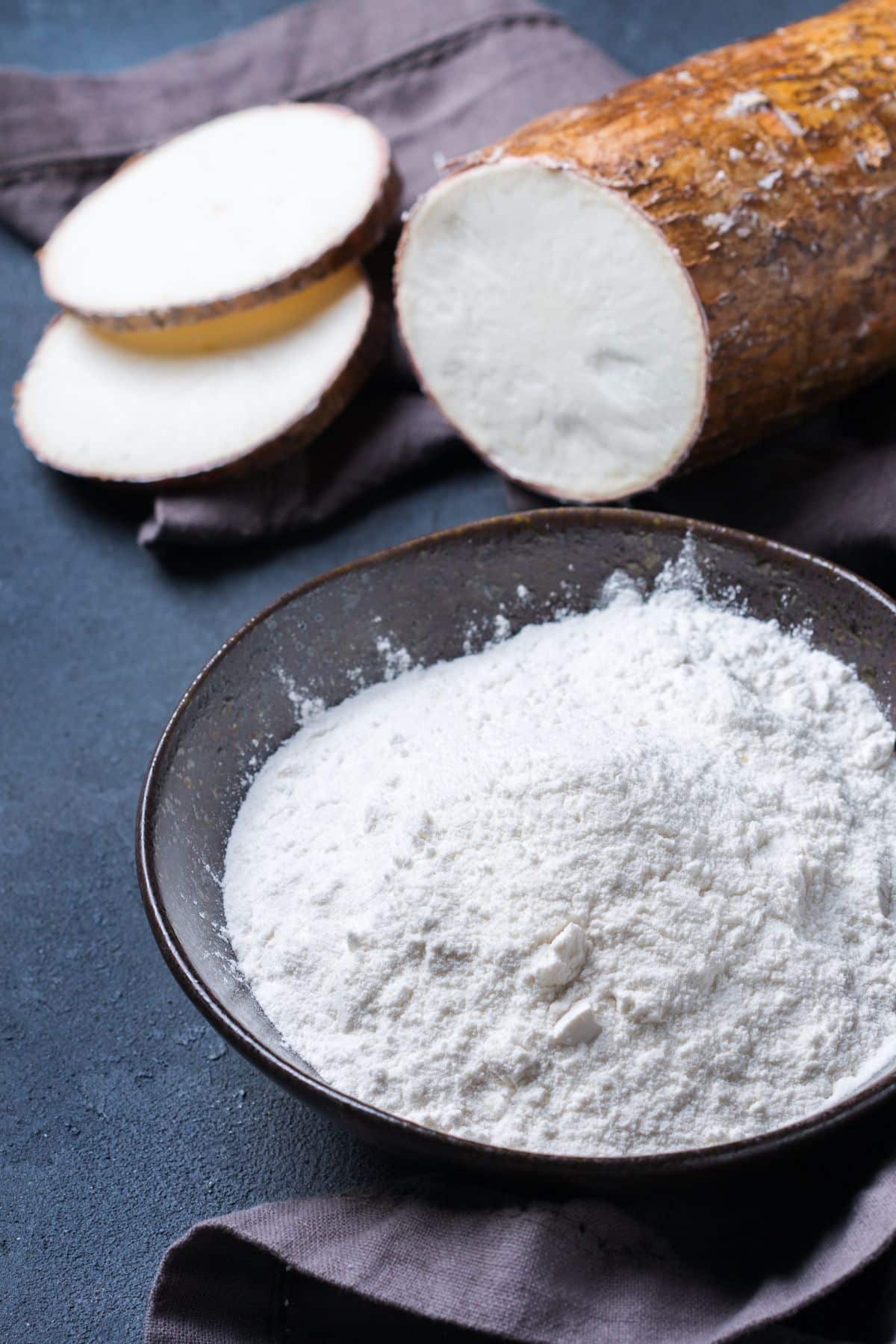 Bowl of cassava flour with cassava root.